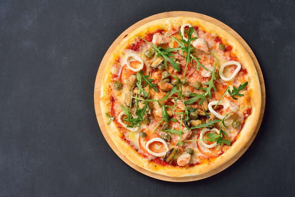 pizza com frutos do mar em uma placa revestida de preto, flat lay
 - Foto, Imagem