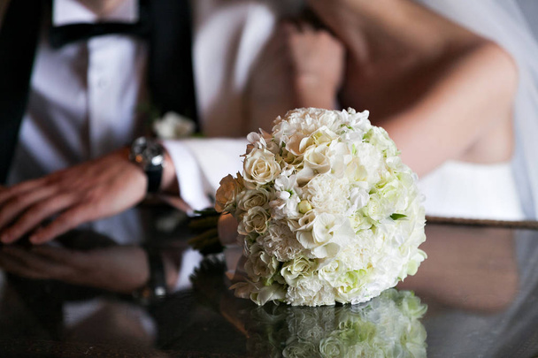 luxury Wedding bouquet. The concept of marriage and love. accessories for just married ceremony close-up. Fresh flowers. the couple in the background - Foto, Imagem