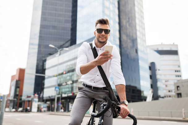 man with bicycle and smartphone on city street - Zdjęcie, obraz