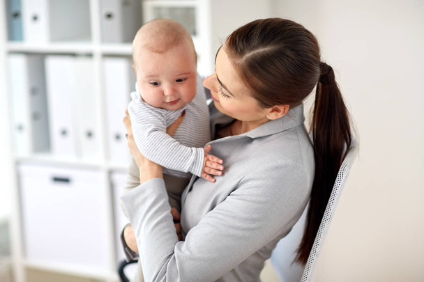 happy businesswoman with baby at office - Foto, Imagem