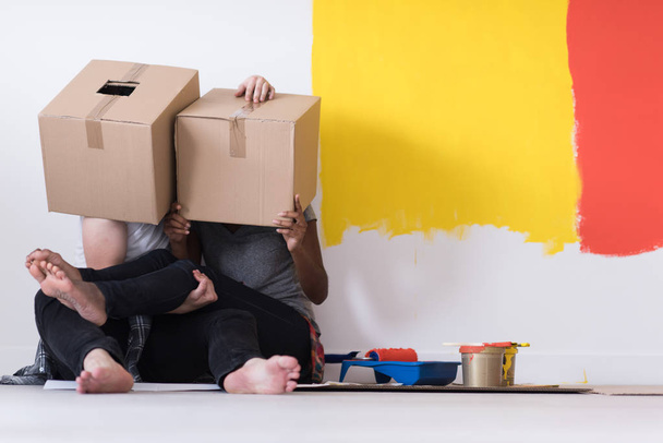 молода багатоетнічна пара грає з картонними коробками
 - Фото, зображення