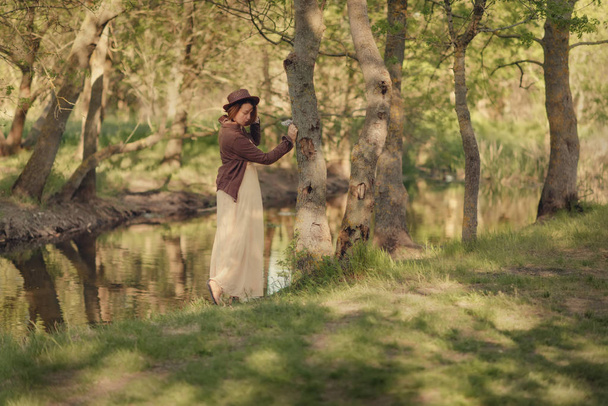 Frau mit Hut im Wald am Fluss - Foto, Bild