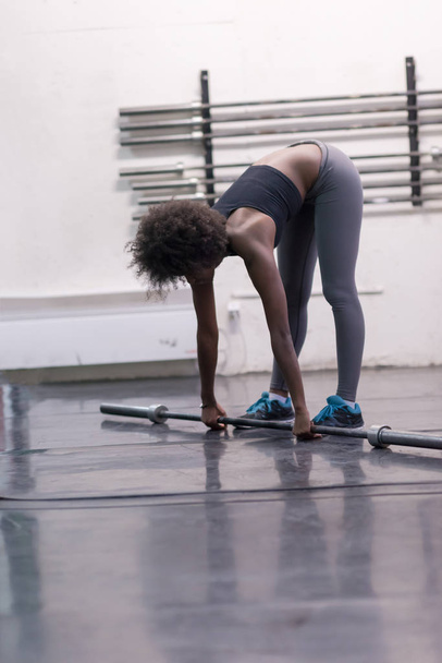 black woman lifting empty bar - Foto, Bild