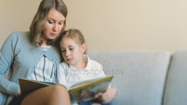 мать и дочь читают книгу. - Кадры, видео