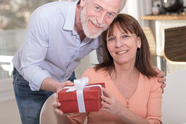 Mature couple with gift box - Фото, зображення