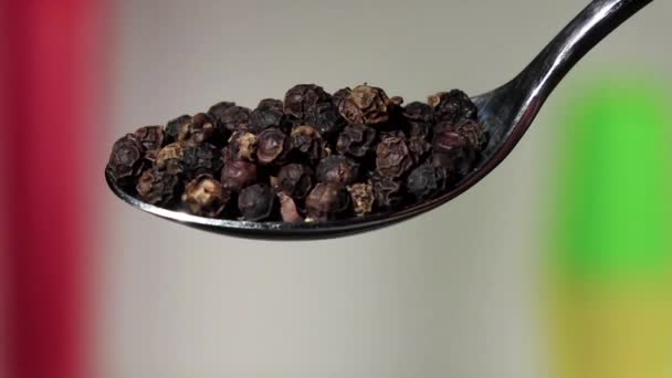 schwarze Paprika-Erbsen, die aus dem Eisenlöffel fallen. verschwommener Hintergrund. Zeitlupe - Filmmaterial, Video