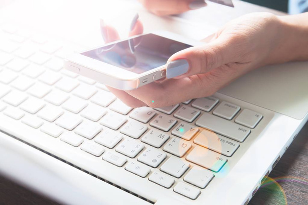 Жінка рука використовує мобільний пристрій і ноутбук на столі, Інтернет-магазин і концепція маркетингу
 - Фото, зображення