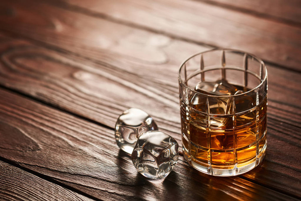 Glass of whiskey with ice cubes  - Foto, afbeelding
