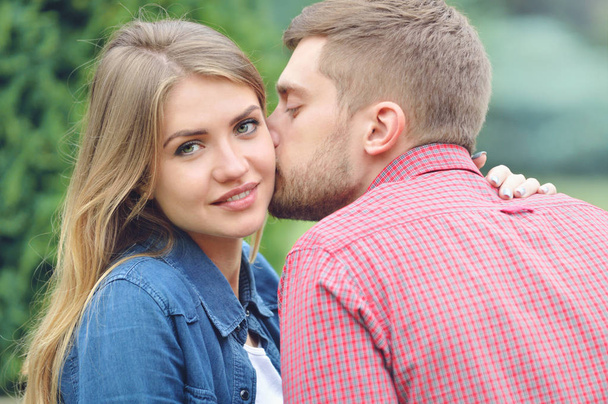 Молодая красивая девушка смотрит в камеру во время поцелуя
 - Фото, изображение