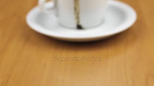 Video of white cup with coffee is on the table. Dolly shot. Close-up. - Filmati, video