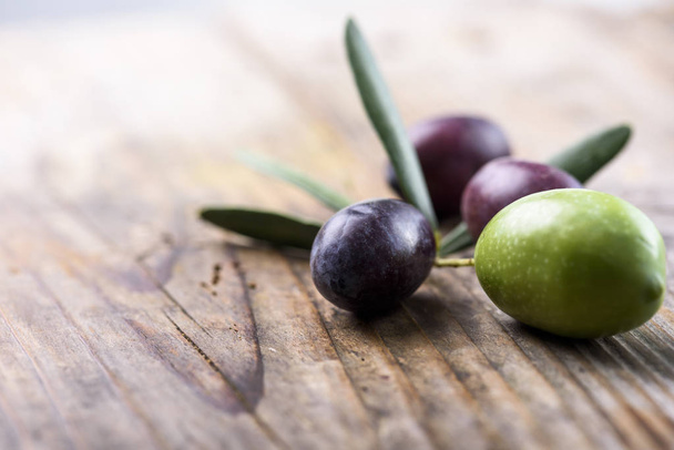 Fruta de olivo sobre mesa de madera
 - Foto, Imagen