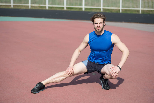 athletic bearded man with muscular body stretching on running tr - Zdjęcie, obraz