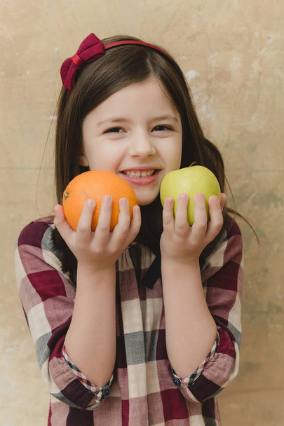 fruit near happy face, little girl with green apple, orange - Fotoğraf, Görsel