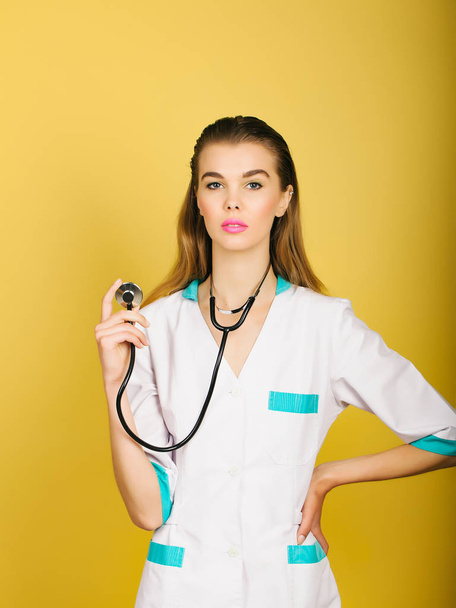 Cute woman doctor standing with stethoscope in hand - Zdjęcie, obraz
