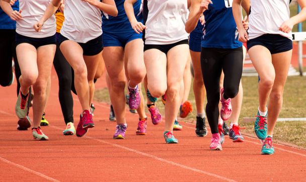 High School Girls corrida em uma pista
 - Foto, Imagem