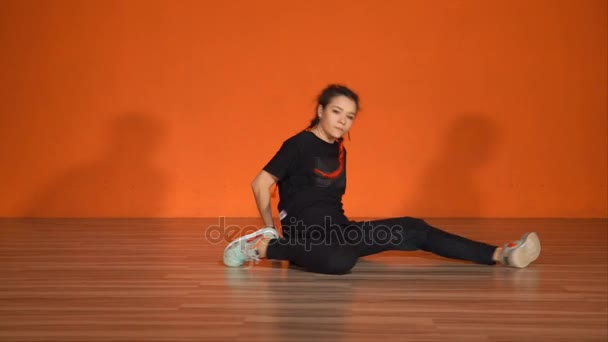 Молодая девушка танцует нижний брейк-данс, используя все тело для движений
 - Кадры, видео