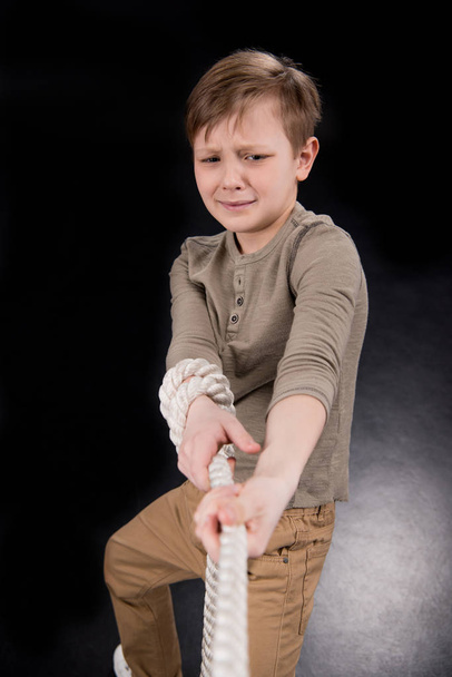 少年が縄を引っ張る - 写真・画像