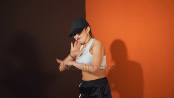 Μια ενεργητική νεαρή γυναίκα εκτελεί χορού hip hop, μετακινώντας ολόκληρο το σώμα - Πλάνα, βίντεο