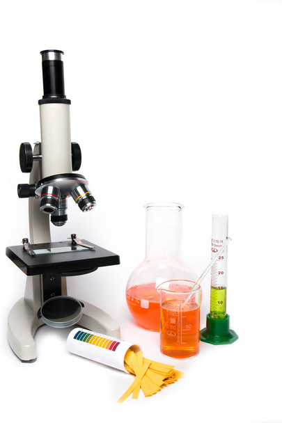 Microscope and laboratory glassware on a white background - Fotó, kép