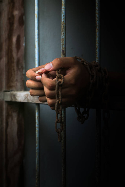 Prisonnier avec chaîne tenant le bar de la prison
 - Photo, image