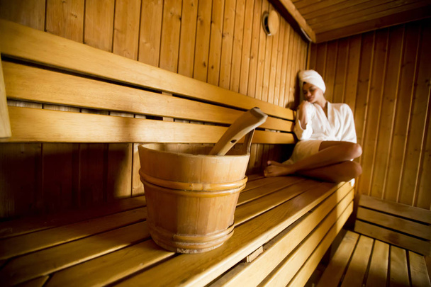 Жінка відпочиває в дерев'яній сауні
 - Фото, зображення