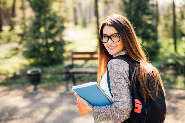 Красивая студентка улыбается перед камерой на кампусе университета
 - Фото, изображение