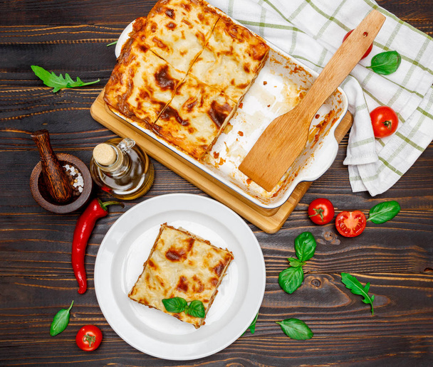 Portion of tasty lasagna on wooden backgound - Foto, Imagem