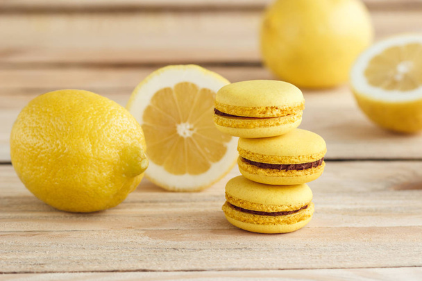 Yellow french macarons with lemons on the wooden board - Fotó, kép