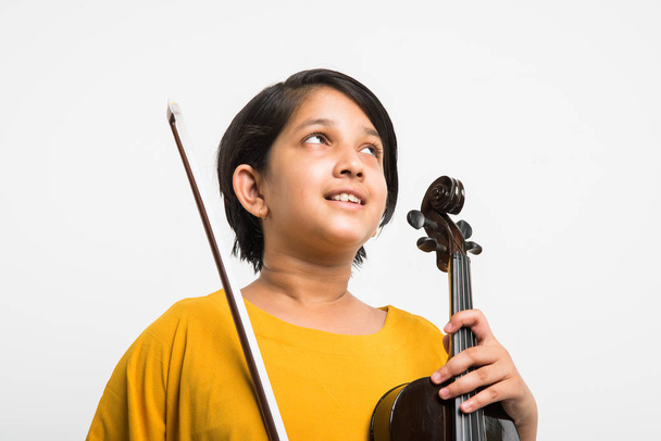 Intialainen tyttö oppii soittamaan viulua, eristetty valkoisella taustalla
 - Valokuva, kuva