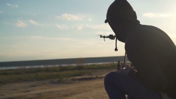 Nuori mies istuu kaukosäädin lähellä lentävät drone lähikuva ammuttu
 - Materiaali, video