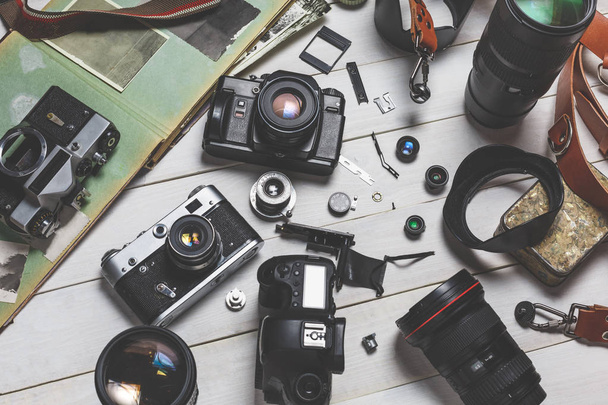 Film cameras, components, digital cameras, and lenses on wooden white background technology development concept - Photo, Image