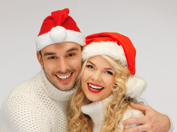 Family couple in sweaters and santa's hats - Zdjęcie, obraz