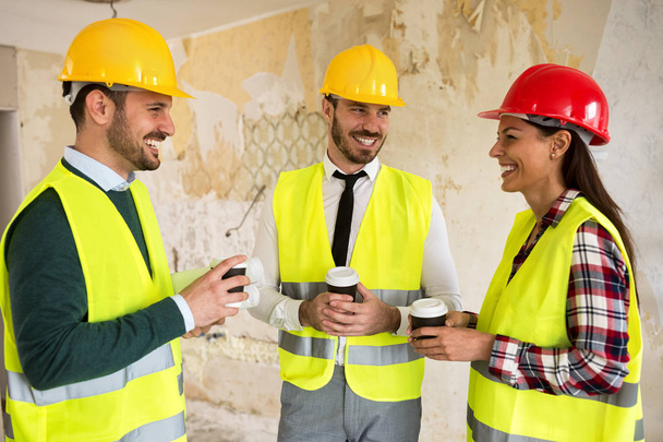 Group of architects talking on coffee break at construction site - Photo, Image