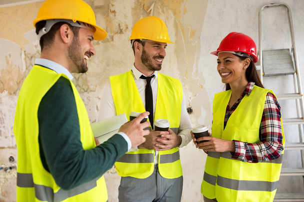 Group of architects talking on coffee break at construction site - 写真・画像