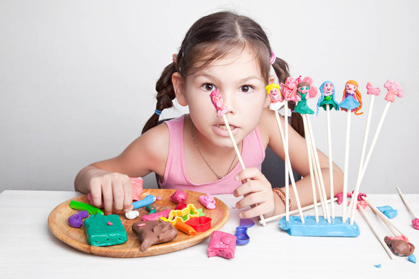 Девушка играет в кукольный театр из глины
 - Фото, изображение