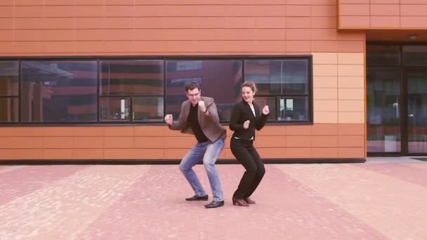 Deux hommes d'affaires s'amusent et rient en dansant près du centre d'affaires moderne. Homme et femme célèbrent le succès. MOTION DE LENT
 - Séquence, vidéo
