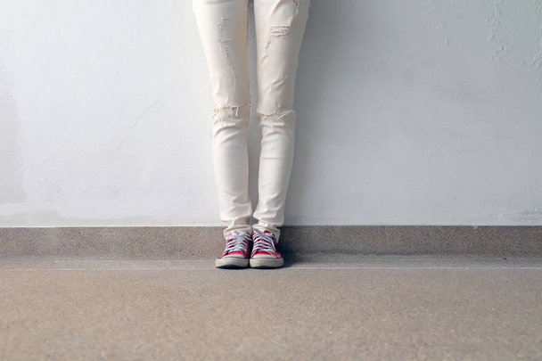 Closeup Photo of From Woman Wearing Red Sneakers On The Concrete Floor Background - Fotografie, Obrázek