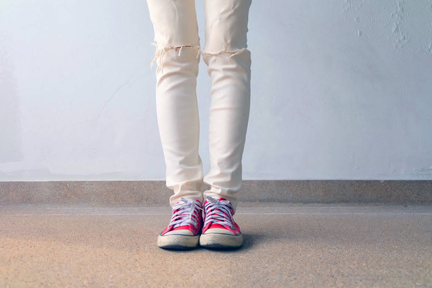Closeup Photo of From Woman Wearing Red Sneakers On The Concrete Floor Background - Valokuva, kuva