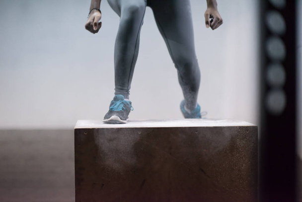 black woman is performing box jumps at gym - Фото, изображение