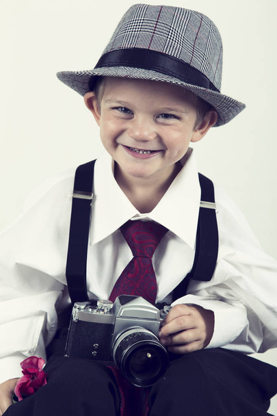 Young boy playing with old camera to be a photographer - Photo, Image
