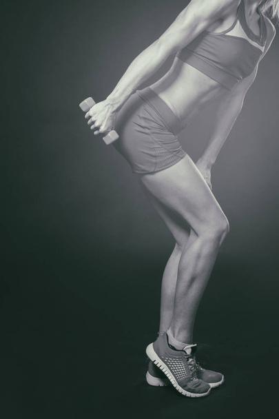 Professional fitness athlete on a dark background. - Foto, Imagem