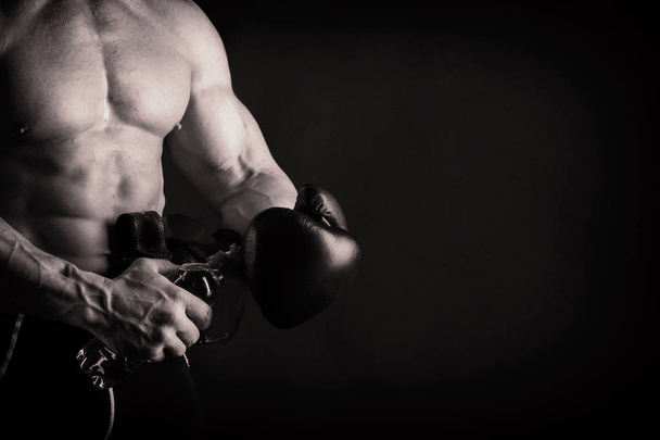 A man with a gorgeous muscular body on a black background - Fotografie, Obrázek