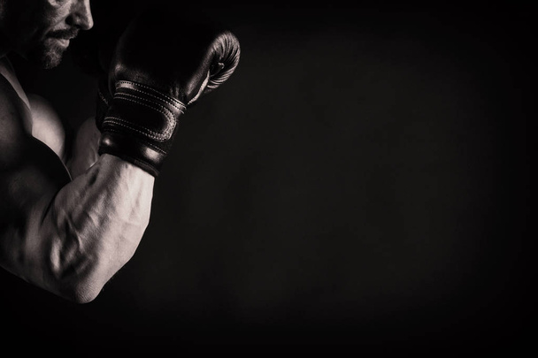Ένας άνθρωπος με ένα πανέμορφο μυώδες σώμα σε μαύρο φόντο - Φωτογραφία, εικόνα