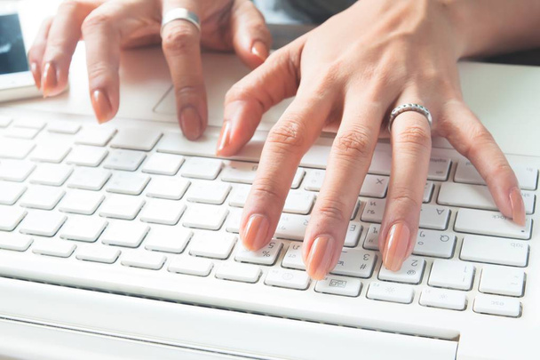 Lähikuva naisen kädet kirjoittamalla kannettavan tietokoneen näppäimistö, Työskentely nainen, Valikoiva keskittyä
 - Valokuva, kuva