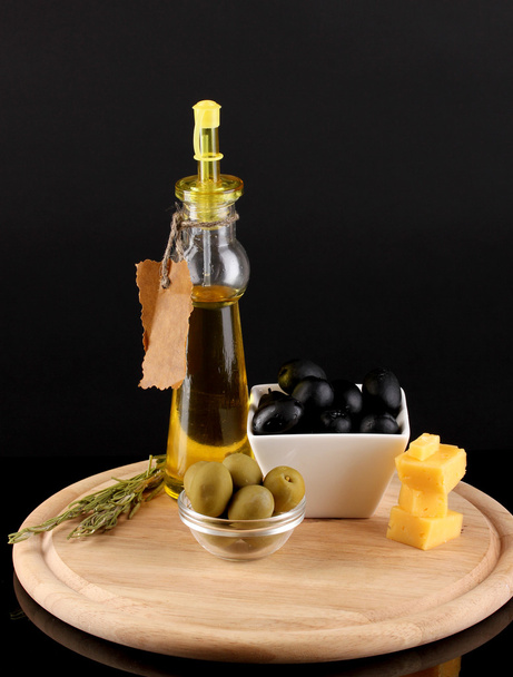 Fekete és zöld olajbogyó, rozmaringos, olívaolaj és sajttal-fedélzeti elszigetelt a fekete tál - Fotó, kép