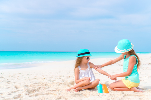 Děti použití sluneční krém na sebe na pláži. Koncepce ochrany před ultrafialovým zářením - Fotografie, Obrázek
