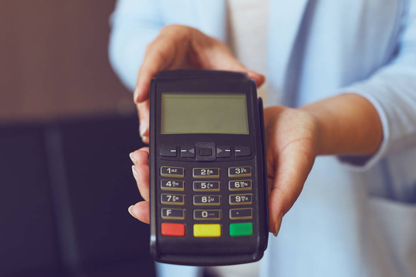Female hands holding a payment terminal - Foto, Imagen