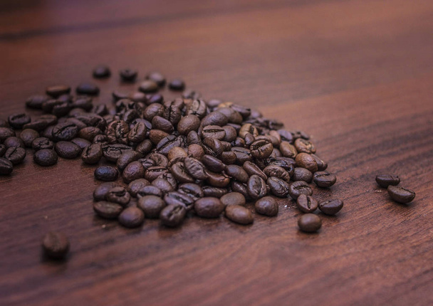 Чорні кавові зерна на коричневому дереві
 - Фото, зображення