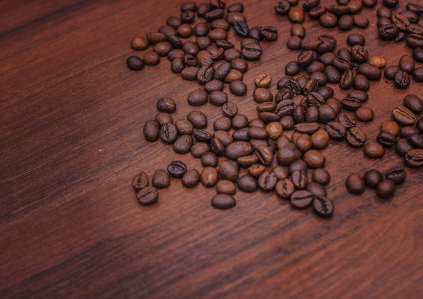 Black coffee beans on a brown tree - Photo, Image