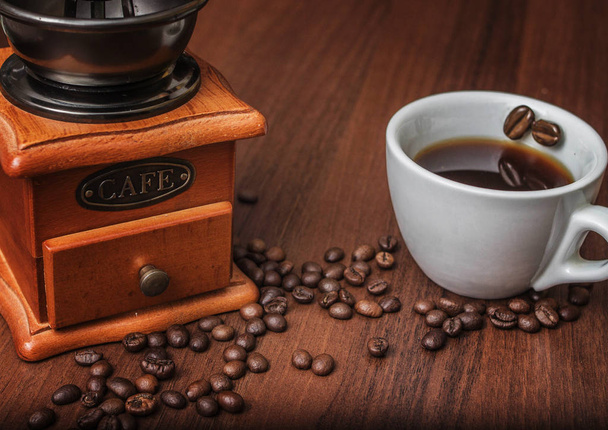 eine Tasse Kaffee mit einer Kaffeemühle auf einem Baum - Foto, Bild